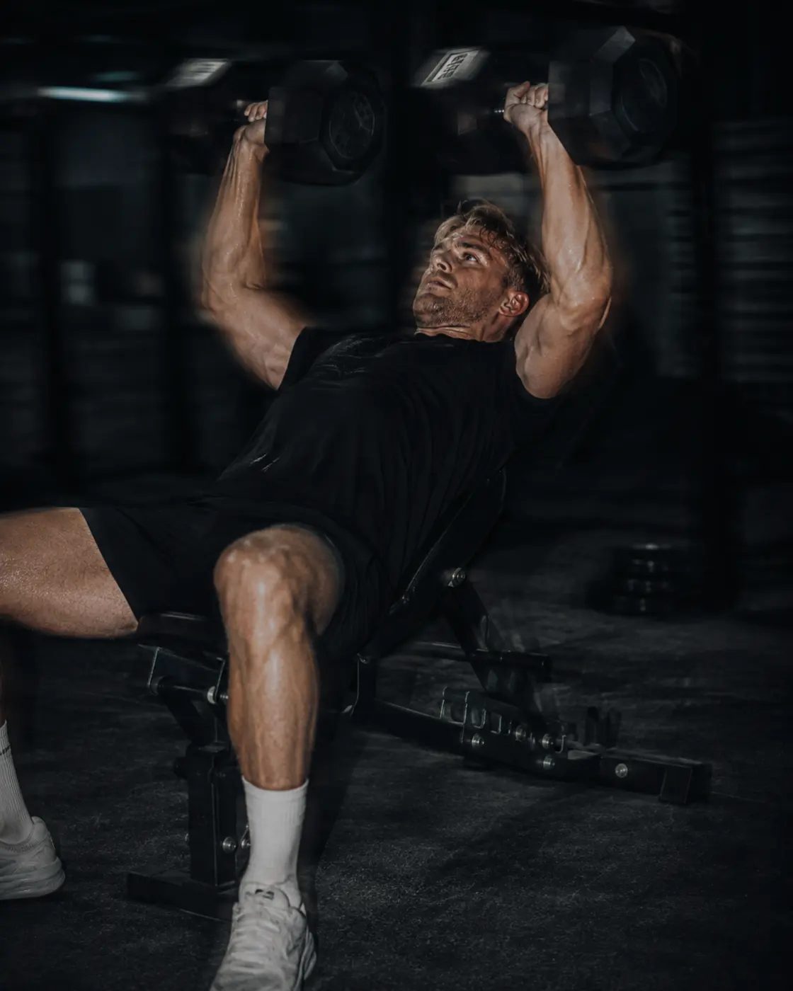 An incline dumbbell press at the top of the rep